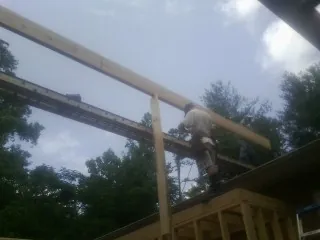 Carpenter setting a ridge beam over a new addition frame — Ice Dam Removal by Roofing Brothers in Touchet