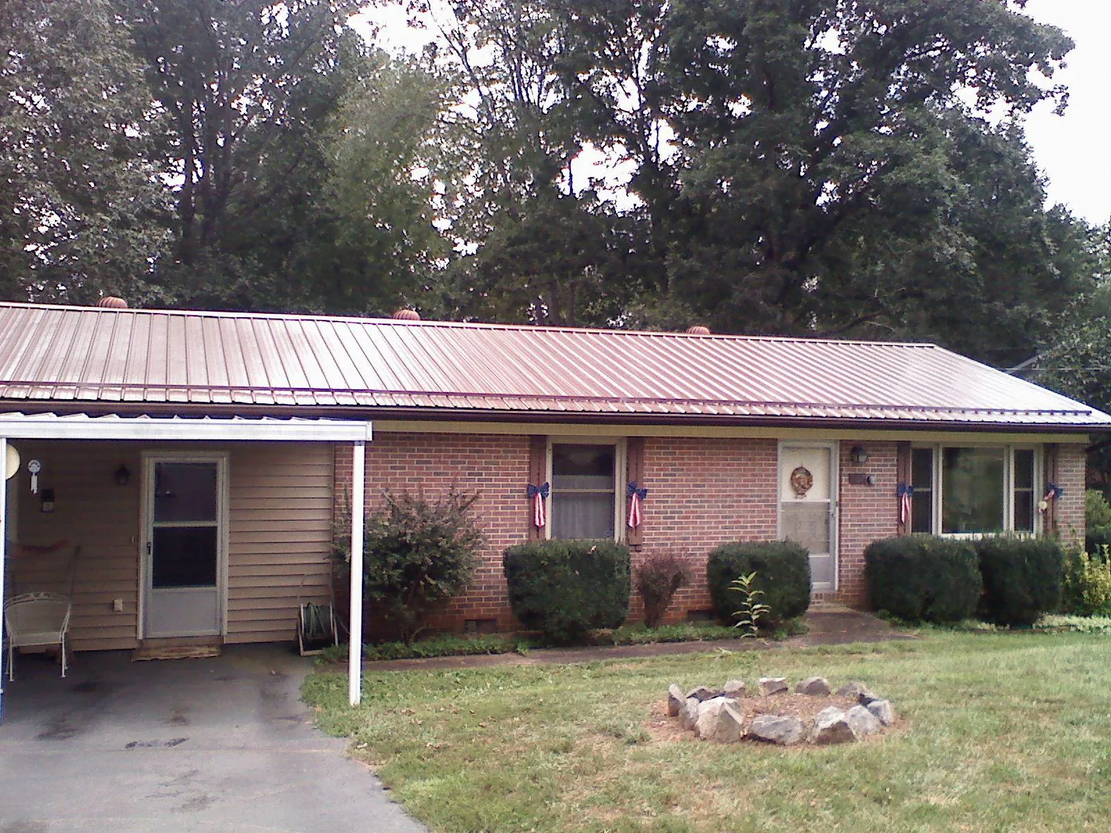 Bronze metal roof and carport on a brick ranch home — Roof Repair work by our crew in Touchet