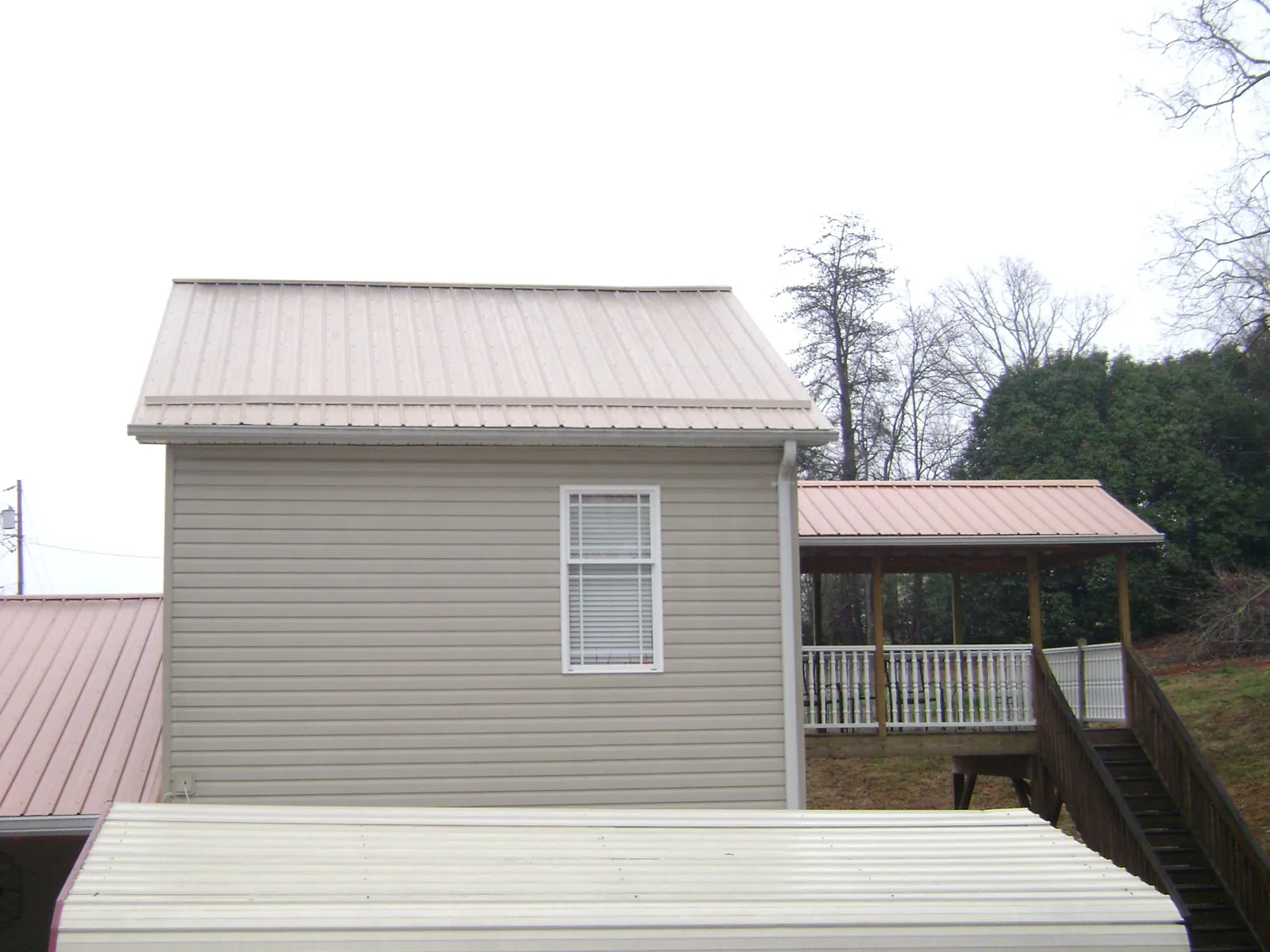 Tan metal roofs on a two story addition and attached porch, from a Roof Replacement job in Touchet